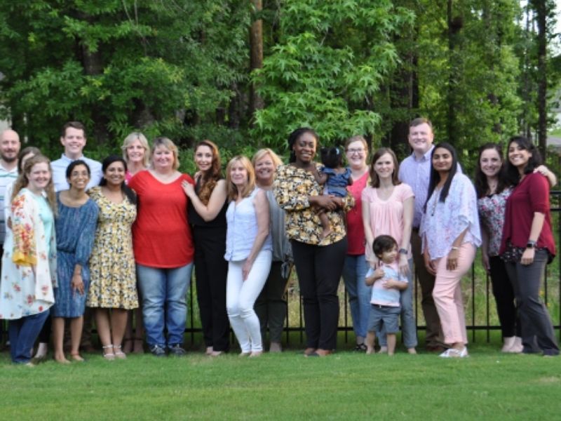 Students and family members pose in an outdoor setting.